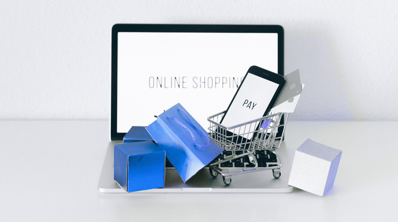 Mini cart and blue packages on a laptop screen showing "Online Shopping"